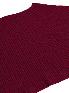 Close-up of elegant burgundy plissé textured fabric for women's fashion vacation set