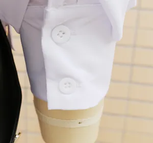Detailed view of white shirt cuff featuring two round buttons on a professional mannequin