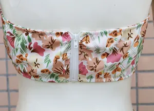 Dettaglio della cerniera bianca sul retro di un completo a due pezzi floreale da donna