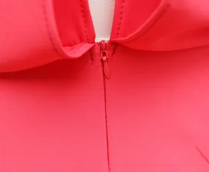 Close-up of the hidden zipper detail on a vibrant red sleeveless summer romper