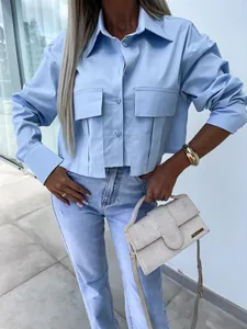 Detail view of light blue oversized shirt with large chest pockets and batwing sleeves.