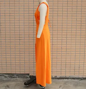 Side view of vibrant orange two-piece set including bra top and maxi pinafore dress