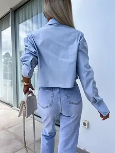 Detailed back view of a light blue cropped shirt with loose batwing sleeves and button cuffs