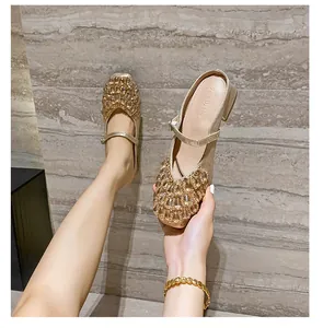 Close-up of champagne Mary Jane block heel mules with sparkling rhinestone toe details.