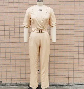 Detailansicht eines beigen Kurzarm-Jumpsuits mit Reverskragen und passendem Gürtel.