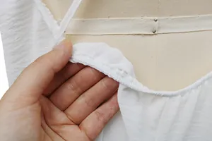 Primer plano de la textura de la tela blanca transpirable y el dobladillo del vestido