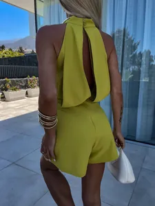 Back view of a lime green halter neck sleeveless romper with elegant backless detail