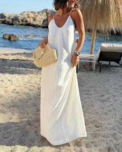 Elegante vestido largo blanco de tirantes finos en una soleada escena de vacaciones de playa