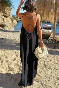 Vista posterior de un vestido largo de verano negro con espalda descubierta en la playa