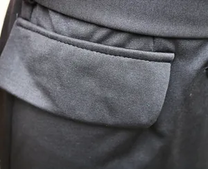 Macro view of pocket detail and fine texture of the black commuter dress