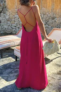 Vista trasera de un vestido largo de playa fucsia con espalda abierta y tirantes