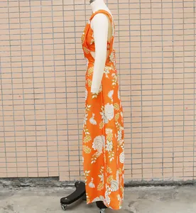 Detailed side view of an orange floral two-piece maxi dress set shown on a mannequin