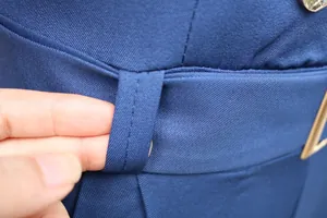 Detailaufnahme von Gürtelschlaufe und Stoffnähten an blauem, schmalem Damen-Jumpsuit.
