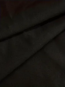 Gros plan sur la texture du tissu plissé noir pour robe ample à manches longues