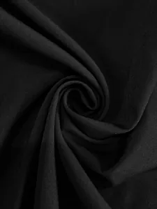 Détail en gros plan du tissu plissé noir lisse montrant la texture et le drapé