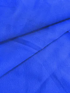 Gros plan haute résolution sur la texture du tissu bleu vif pour robe plissée grande taille