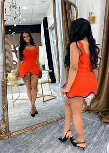 Stylish orange sleeveless mini dress with wavy hem detail in a mirror room setting.