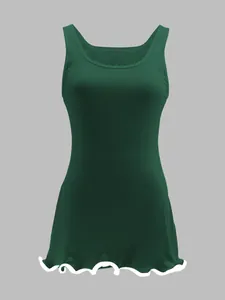 Detail showing the ribbed knit texture and lettuce edge hem of the green mini dress