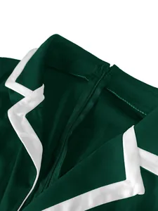Detalle del escote de un mono verde con solapa blanca en contraste y cremallera.