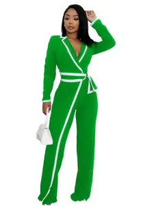 Vista detallada de un elegante mono verde de manga larga con cinturón blanco chic.
