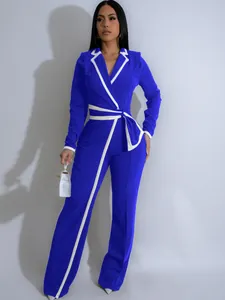 Elegante mono azul real de manga larga con ribetes blancos en contraste y cinturón.