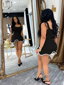 Black sleeveless bodycon mini dress featuring stylish white wavy ruffled hem details
