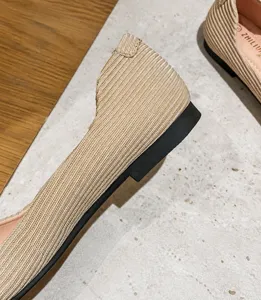 Dettaglio del tacco piatto da 1 cm su scarpe beige da donna con punta quadrata