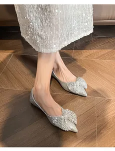 Close-up of silver sequin pointed flats featuring a delicate bow detail for weddings.
