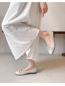 Detailed view of beige French ballet flats with delicate bow and round toe