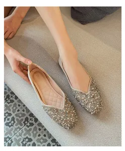 Detailed macro view of square-toe flat shoes with pearl and rhinestone embellishments