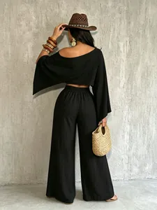 Vista trasera del conjunto negro de top con hombro descubierto y pantalón ancho