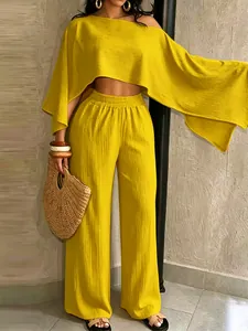 Elegante conjunto de dos piezas amarillo con top sin hombros y pantalones anchos