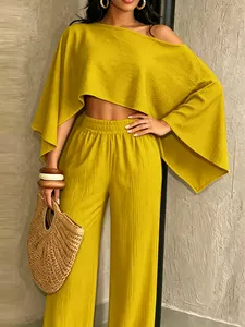 Primer plano del top amarillo mostaza con hombros descubiertos y pantalones anchos a juego