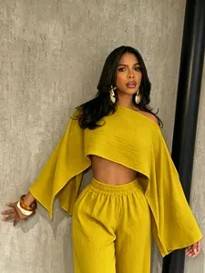 Conjunto playero de dos piezas amarillo mostaza con top corto asimétrico y pantalón.