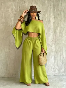 Vista de cuerpo completo del conjunto verde lima con top asimétrico y pantalón ancho