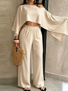 Vista detallada del conjunto de dos piezas beige con top asimétrico y hombros descubiertos.