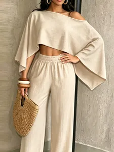 Detalle de conjunto playero beige texturizado con top corto de hombro caído y pantalón
