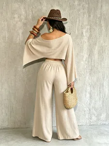 Vista trasera de elegante conjunto de top beige sin hombros y pantalón ancho moda