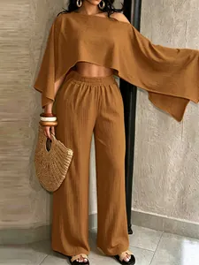 Conjunto ocre de dos piezas con top corto asimétrico y pantalones anchos para vacaciones.