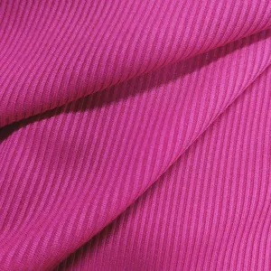 Detailed close-up macro view of hot pink ribbed knit fabric texture for fashion jumpsuit apparel