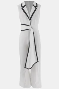 Eleganter weißer ärmelloser Jumpsuit mit V-Ausschnitt, Kontrastbesatz und Gürtel.