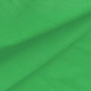 Detailaufnahme der leuchtend grünen Stofftextur eines eleganten Sommer-Jumpsuits