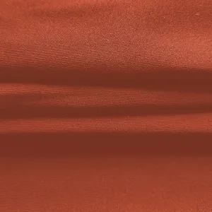 Makroansicht der atmungsaktiven orangefarbenen Stofftextur für Sommer-Jumpsuits