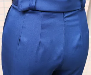 Detailansicht der Taillenabnäher und Gürtelschlaufen an einem blauen, schmalen Jumpsuit.