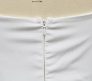 Detaillierte Makroansicht des nahtlosen verdeckten Reißverschlusses an einem weißen Kleid