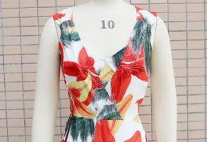 Macro detail of V-neck sleeveless dress featuring vibrant tropical lily and palm leaf print
