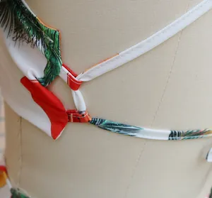 Close-up detail of white tropical palm leaf print straps and fine stitching on top