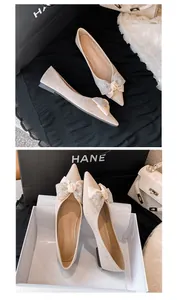 Elegante beige spitze Ballerinas mit einer Strass-Schleife und glitzerndem Finish.