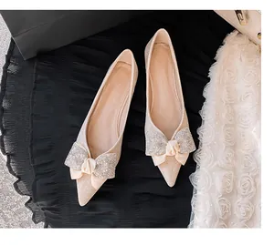 Elegante beige spitze Ballerinas mit einer atemberaubenden, mit Strass verzierten Schleife