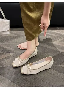 French retro beige leather ballet flats with gold cap toe and bow detail decoration.